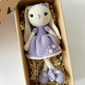 Crocheted doll with a purple dress in a box